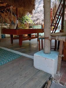 a wooden table in a room with a palm tree at El Puente in Sipacate