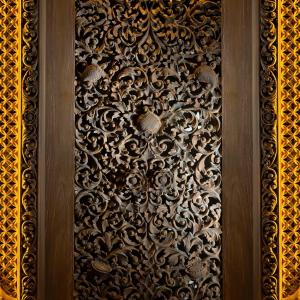 een houten deur met een metalen ontwerp erop bij The Apurva Kempinski Bali in Nusa Dua
