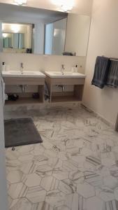 a bathroom with two sinks and a large mirror at Departamento en Puebla (en torre Artema- zona Angelópolis) in Puebla