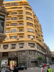 een groot geel gebouw in een stadsstraat bij TUT Hotel Downtown in Caïro