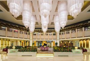 a lobby with chandeliers and flowers in a building at Kempinski Hotel Dalian in Dalian