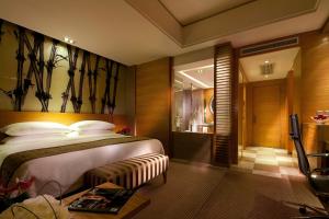 une chambre d'hôtel avec un lit et une télévision dans l'établissement Kempinski Hotel Dalian, à Dalian