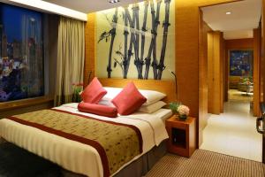 um quarto com uma cama grande e almofadas vermelhas em Kempinski Hotel Dalian em Dalian
