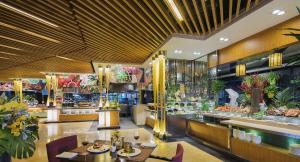 un restaurante con mesas y sillas y un buffet en Kempinski Hotel Dalian en Dalian