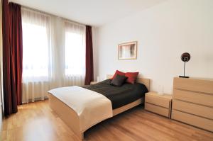 1 dormitorio con 1 cama, vestidor y ventanas en Leda Apartments, en Budapest