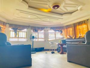 sala de estar con cortinas, mesa y sillas en Legends Castle Suites en Gwarinpa