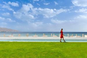 Una donna che cammina lungo un marciapiede vicino alla spiaggia di Kempinski Hotel Aqaba ad Aqaba