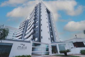 a tall white building with a sign in front of it at Apartamento Aconchegante Maia 404 in Caxias do Sul