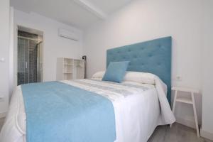 a bedroom with a large bed with a blue headboard at Los Miradores del Arrabal in Toledo