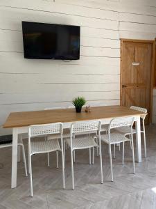 Ocumare de la Costa的住宿－Aqua Vista La Ciénaga，一张带椅子的木桌和墙上的电视