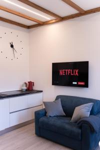 a living room with a blue couch and a clock on the wall at Belvedere 237 Lakeview Apartment Leo Bakst in Ghiffa