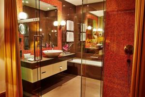 W łazience znajduje się umywalka i przeszklony prysznic. w obiekcie Kempinski Hotel Das Tirol w mieście Jochberg