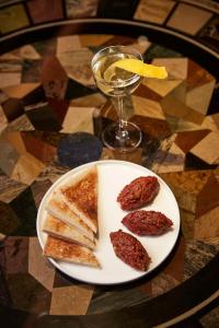 un piatto con polpette e pane tostato su un tavolo con una bevanda di Vier Jahreszeiten Kempinski München a Monaco
