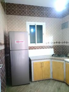 Villa piscine 4 chambres في Hennchir Ksar Rhaleb: مطبخ مع ثلاجة ونافذة