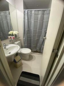 a bathroom with a toilet and a sink and a shower at Azure Beach view near airport in Manila
