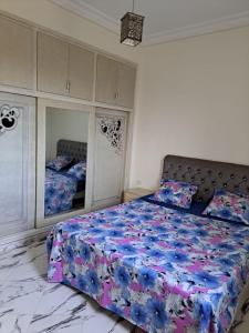 um quarto com uma cama grande e um espelho em Villa piscine 4 chambres em Hanshīr Qaşr Ghallāb