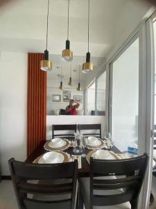 a dining room with a table and chairs and a window at Azure Beach view near airport in Manila