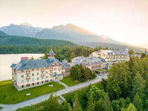 an aerial view of a resort with a lake and mountains at Grand Hotel Kempinski High Tatras in Štrbské Pleso