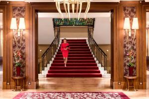 a woman walking down the stairs in a building at Grand Hotel Kempinski High Tatras in Štrbské Pleso