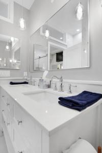 a white bathroom with two sinks and a mirror at DC's Best Address -10min to White HSE - 500 mbps in Washington, D.C.