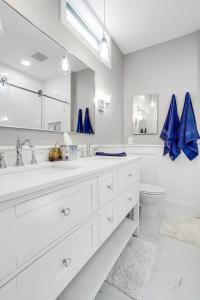 Baño blanco con lavabo y aseo en DC's Best Address -10min to White HSE - 500 mbps, en Washington