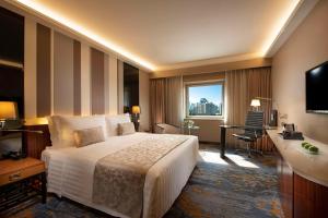 Kempinski Hotel Beijing Yansha Center في بكين: غرفة الفندق بسرير كبير ومكتب