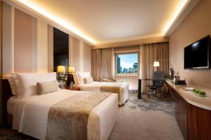 um quarto de hotel com duas camas e uma televisão em Kempinski Hotel Beijing Yansha Center em Pequim