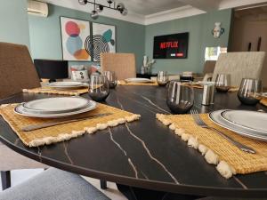 a dining room table with plates and glasses on it at Number Nine Triangle d'Or by IB Signature - Chic 3-Bedroom family apartment in sought-after area, 24 x7 Security - Self check-in - Parking - City View with terrace - Walk to Cafes! City Centre in Casablanca