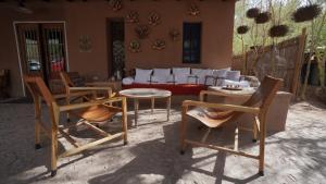 a living room with chairs and a table and a couch at Ckoi Atacama Lodge in San Pedro de Atacama