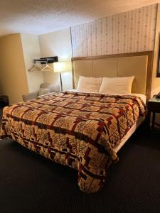 Una habitación de hotel con una cama con una manta. en Columbus Motor Inn, en Seattle