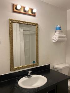 y baño con lavabo y espejo. en Columbus Motor Inn, en Seattle