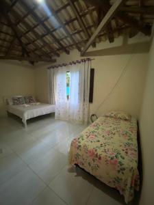 a bedroom with a bed and a window at ALOHA - PRAIA DO SONO - in Paraty