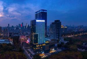 a lit up skyscraper in a city at night at Kempinski Hotel Nanjing in Nanjing