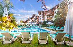 a pool at a hotel with chairs and umbrellas at Kempinski Hotel Grand Arena Bansko in Bansko