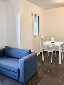 uma sala de estar com um sofá azul e uma mesa em CHARMANT T2 em Feyzin