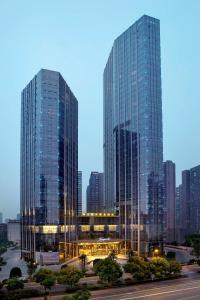 長沙市にあるKempinski Hotel Changshaの夕暮れ時の高層ガラスの高層ビル