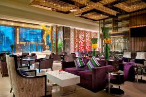 un vestíbulo de hotel con sofás púrpura, mesas y sillas en Kempinski Hotel Changsha en Changsha