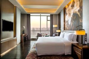 長沙市にあるKempinski Hotel Changshaの大きなベッドと大きな窓が備わるホテルルームです。