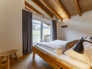 a bedroom with a bed and a large window at Schneeflocke Leogang in Leogang