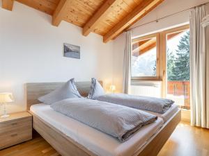 a bedroom with a bed and a large window at Hoog Hout in Hippach