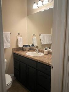 a bathroom with a sink and a toilet and a mirror at Cozy Springs in Mesquite