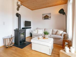 Una sala de estar con un sofá y una estufa de leña. en Van Dik Hout, en Hippach