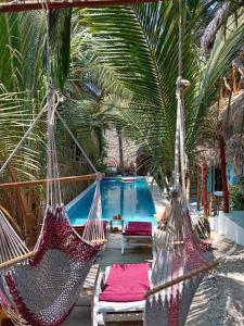 a resort with a hammock and a swimming pool at El Puente in Sipacate