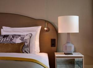 a bedroom with a bed with a lamp on a night stand at Hotel Taschenbergpalais Kempinski in Dresden