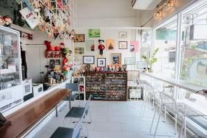 un restaurante con mesas y sillas en una habitación en The Memory Shop Coffee Studio X Poshtal, en Lampang