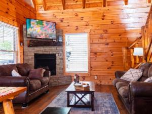 uma sala de estar com sofás de couro e uma lareira em Grand Mountain View Lodge By Ghosal Luxury Lodging em Sevierville