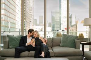 Ein Mann und eine Frau auf einer Couch in der Unterkunft SoHo Hotel Toronto in Toronto