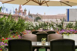 a table and chairs with flowers on a balcony at Hotel Baltschug Kempinski Moscow in Moscow