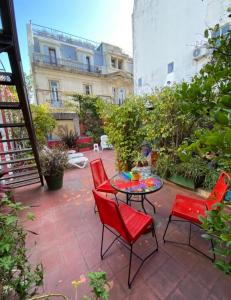 a patio with red chairs and a table at LGY Bed & Breakfast ONLY MEN-SOLO HOMBRES in Buenos Aires