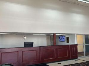 an empty waiting room with a desk and a tv on a wall at Motel 6 Forsyth, GA Tift College in Forsyth